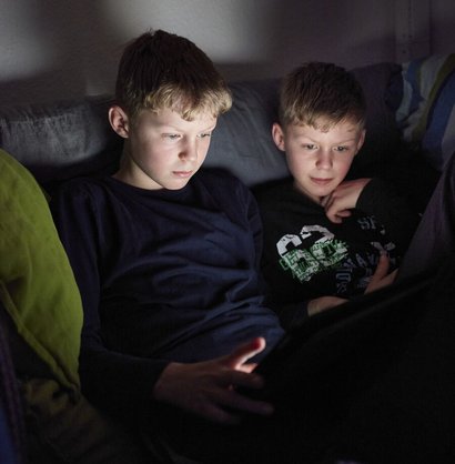 Zwei Jugendliche schauen auf ein Tablet.
