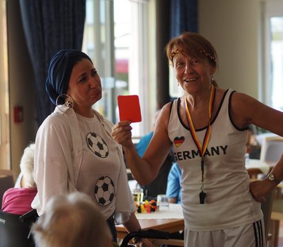 Das Bild zeigt eine Szene einer Fußball- oder WM-Party in einem Seniorenzentrum.