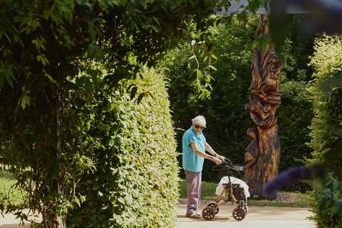 Bewohnerin steht im Garten des AWO-Seniorenzentrums Am Stadtpark