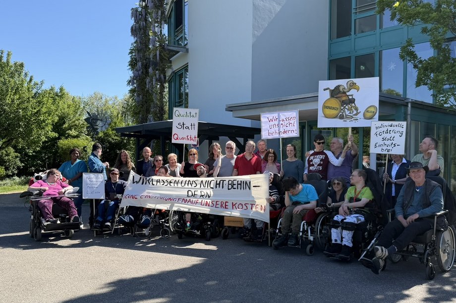 Eine Gruppe von Bewohnenden und Mitarbeitenden von leben und wohnen demonstriert mit Plakaten.